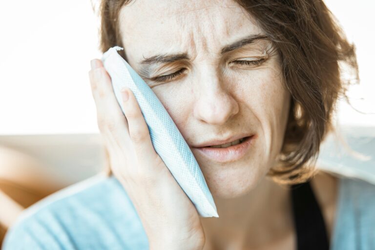 a women holds her jaw in pain